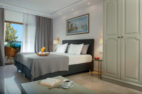 a hotel room with a bed and a table at Possidi Holidays Resort & Suite Hotel in Possidi