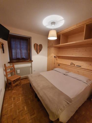 a bedroom with a large bed and a window at Casa Andreola in Valfurva