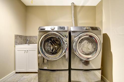 two washing machines sitting next to each other in a laundry room at Rodee Homestay in West Kelowna