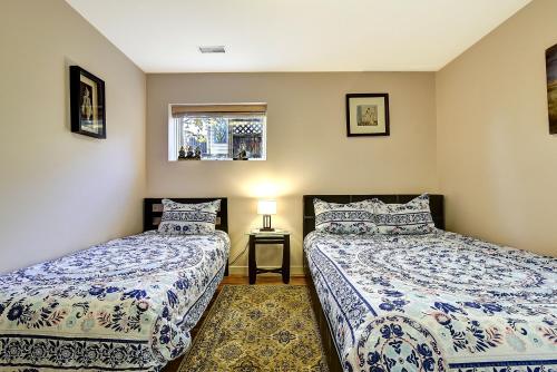 a bedroom with two beds and a window at Rodee Homestay in West Kelowna