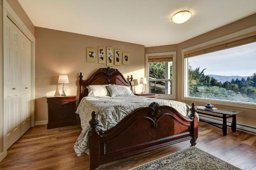 a bedroom with a large bed and a large window at Rodee Homestay in West Kelowna
