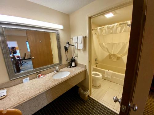 a bathroom with a sink and a toilet and a mirror at Days Inn by Wyndham Morehead in Morehead
