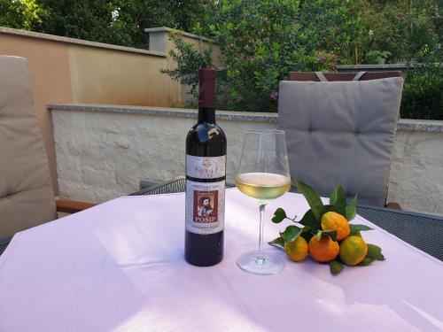 una bottiglia di vino e un bicchiere su un tavolo di MARILU a Korčula