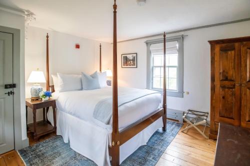 um quarto com uma grande cama branca e uma janela em Anchor Inn em Nantucket