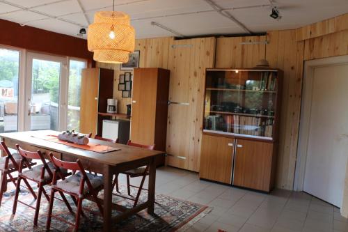 a dining room with a wooden table and chairs at Gesves Côté Jardin in Gesves