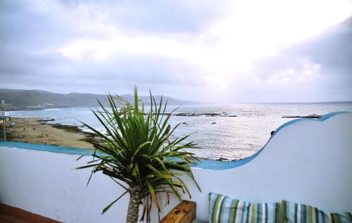 a view from a balcony of a beach with palm trees at HiTide House in Las Palmas de Gran Canaria