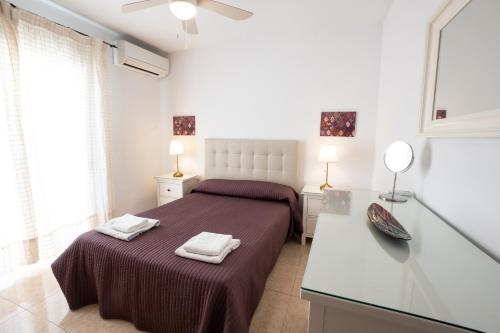 a bedroom with a bed with two towels on it at Casa María in Nerja