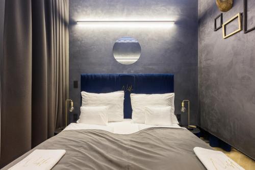 a bedroom with a large bed with a blue headboard at Noble Boutique Hotel - Adults Only in Budapest