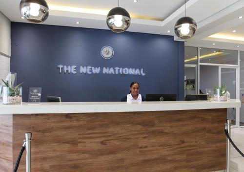 a woman sitting at a reception counter in an office at New National Hotel and Conference in Parow