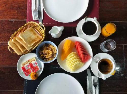 a table with plates of food and a cup of coffee at Sawasdee Home Stay Resort & Pool in Khao Lak