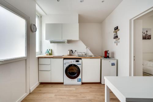 une cuisine blanche avec lave-linge dans l'établissement Apartment 3 people close Eiffel Tower by Weekome, à Paris