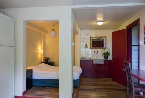 ein kleines Schlafzimmer mit einem Bett und einer Küche in der Unterkunft Hotel Restaurant Oortjeshekken in Ooij