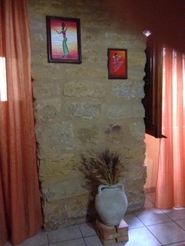 una habitación con una pared de piedra con una planta en un jarrón en B&B Al Dammuso, en Agrigento