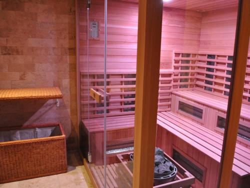 ゴーザウにあるトランシルバニア ヴィラ ＆ スパのピンクの壁のサウナ付きの客室です。