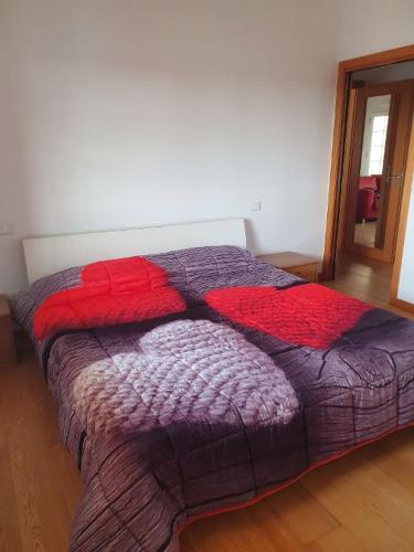 - une chambre dotée d'un lit avec une couverture rouge et violette dans l'établissement Happy house villotta, à Chions