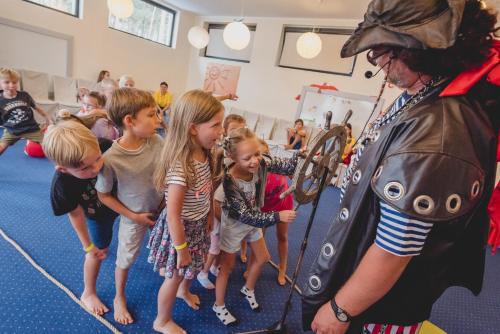a group of children standing next to a man dressed in costume at Columbus Rowy in Rowy