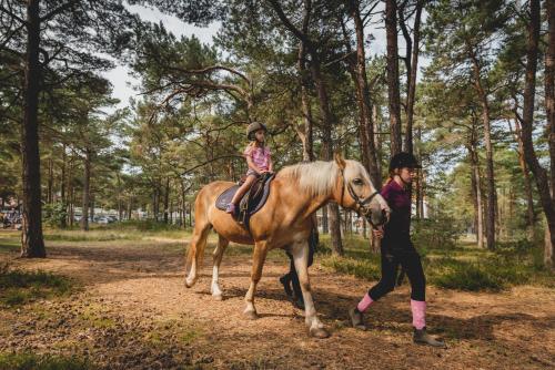 a young girl riding a horse next to a woman at Columbus Rowy in Rowy