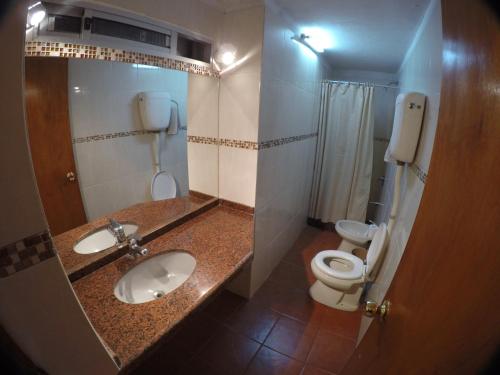 a small bathroom with a toilet and a sink at Hotel Tia in Salto