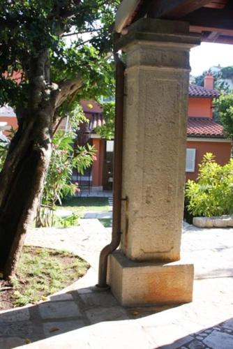 a stone pillar with a tree in the background at STONE HOUSE reTREAT in Mali Lošinj