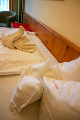 a stuffed animal laying on a bed with two pillows at Ortner's Resort in Bad Füssing