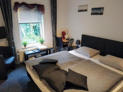 a bedroom with a large bed and a window at Bed & Breakfast Zuidlaren in Zuidlaren