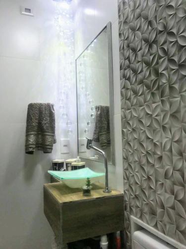 a bathroom with a sink and a mirror at Casa Duplex Condomínio Ipanema no Peró in Cabo Frio