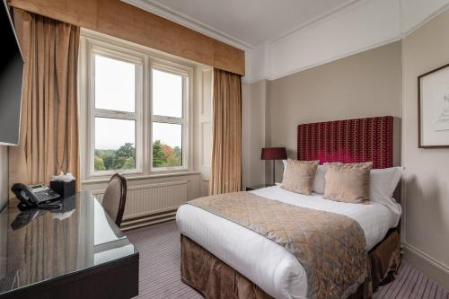 a hotel room with a bed and a window at Hartsfield Manor in Dorking