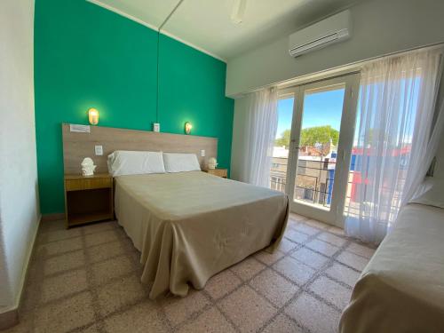 a bedroom with a large bed and a green wall at Hotel California in Mar del Plata