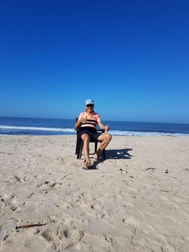 a woman sitting in a chair on the beach at Marari Nadiya in Mararikulam