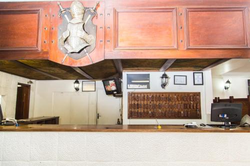 a kitchen with wooden cabinets and a counter top at Hotel Londres in São Lourenço