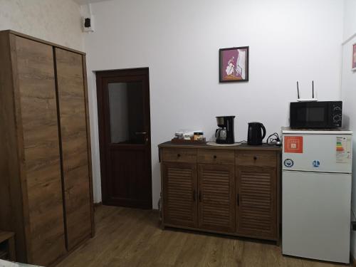 a kitchen with a white refrigerator and a wooden cabinet at Clemence Guesthouse in Braşov