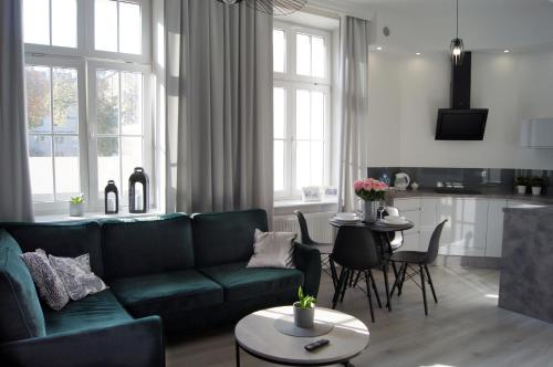 a living room with a green couch and a table at Green Park Apartament in Toruń