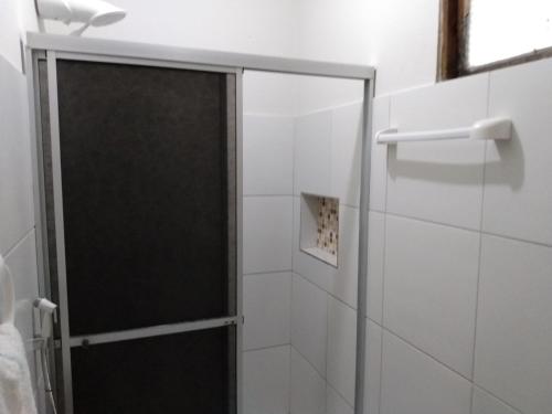 a shower with a glass door in a bathroom at Pousada Fragata in Porto De Galinhas