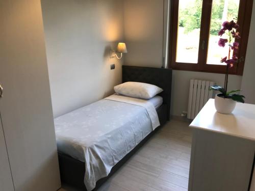 a small bedroom with a bed and a window at Villa Sofia in Baveno