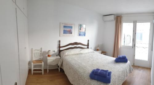- une chambre avec un lit et des serviettes bleues dans l'établissement Marquina, à Cadaqués