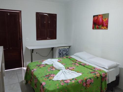 um quarto com uma cama com um cobertor verde em Pousada Fragata em Porto de Galinhas