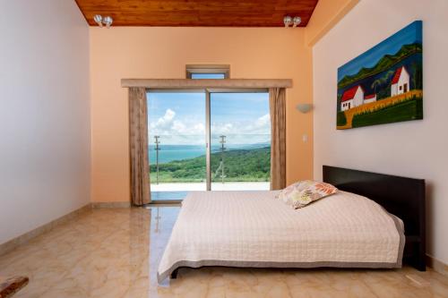 a bedroom with a bed and a window at Lake Arenal Condos in Naranjos Agrios