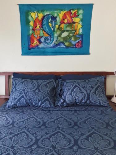 a painting on the wall above a bed at Miller's Guest House in Buccoo