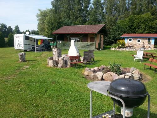 a bbq grill in a yard with a house at Pod Sową in Drawsko Pomorskie