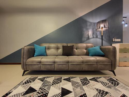 sala de estar con sofá marrón con almohadas azules en Landmark By Katana 4BR Romantic Seaview Homestay Gurney无敌海景四房套房, en Tanjong Tokong