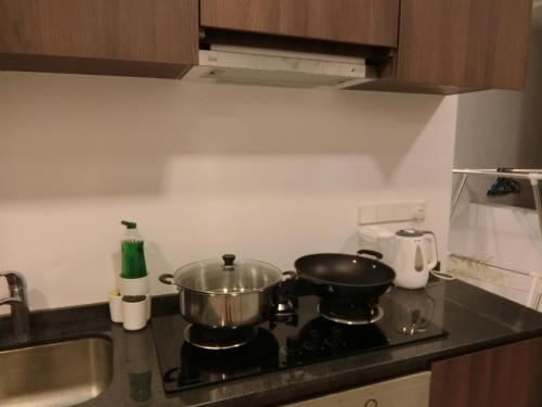 a kitchen with two pots and pans on a stove at Landmark By Katana 4BR Romantic Seaview Homestay Gurney无敌海景四房套房 in Tanjong Tokong