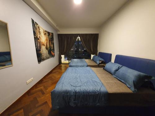 a bedroom with two beds and a blue couch at Landmark By Katana 4BR Romantic Seaview Homestay Gurney无敌海景四房套房 in Tanjong Tokong