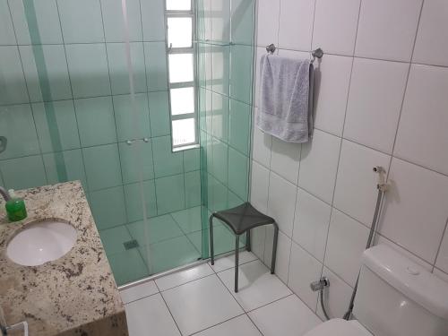 een badkamer met een wastafel en een glazen douche bij Santos Apartamento Frente Mar - Ar Condicionado na Suíte - Garagem Privativa -Internet - TV a Cabo in Santos