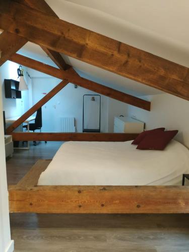a large bed in a room with wooden beams at Attic one bedroom flat in Old Town Lyon in Lyon