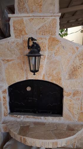 a black door with a light on a stone wall at Apartment Carpe Diem 1 in Utjeha