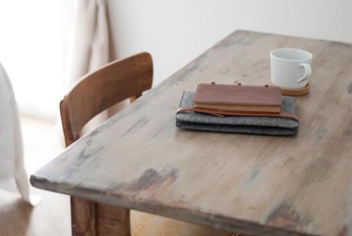 a wooden table with a coffee cup and a notebook on it at L'Alighieri in Monterotondo