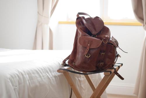 a backpack sitting on a stand next to a bed at L'Alighieri in Monterotondo