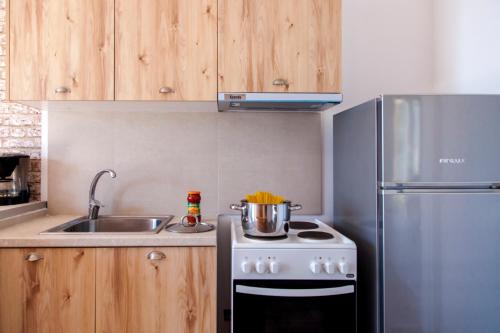 a small kitchen with a stove and a refrigerator at Ble on Blue in Athanion