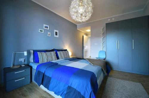 a blue bedroom with a bed and a chandelier at Apartment Vanilla I with beautiful Seaview in Rabac