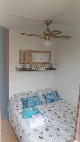 une chambre avec un lit avec un ventilateur de plafond dans l'établissement Appartement T2 avec son rez de jardin de 40 m2 5 couchages 250m de la plage et 15km de l'Arena, à Narbonne-Plage